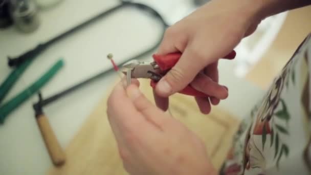 Menschenhände schneiden, mit einer roten Zange langen Draht schnippeln. Nahaufnahme — Stockvideo