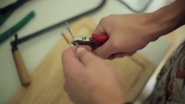 Le mani di uomo appena tagliate, tagliano il filo lungo da pinze rosse. Primo piano — Video Stock