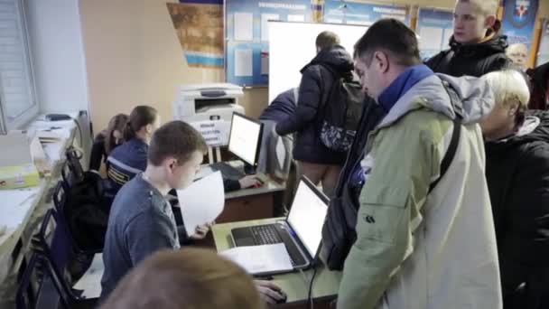 Petrohrad, Rusko - 28 listopadu 2015: Lidé se zaregistrovat na muže s notebookem na emecrom učení. Indoor — Stock video