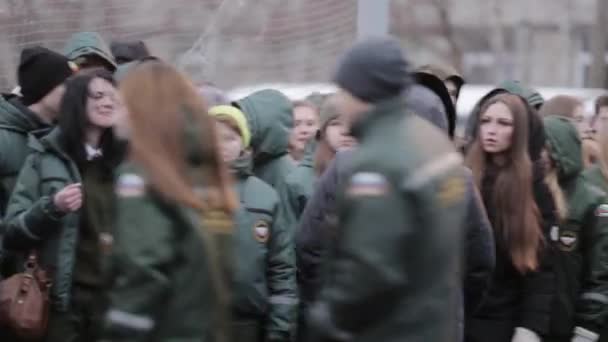SAN PETERSBURG, RUSIA - 28 DE NOVIEMBRE DE 2015: Muchas jóvenes en uniforme verde de esmeralda caminan en el campo de entrenamiento. Nieve. Día. — Vídeo de stock