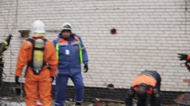 SAINT PETERSBURG, RUSSIA - NOVEMBER 28, 2015: Instructor explain men in orange uniform, respiratory mask. Emercom practice — Αρχείο Βίντεο