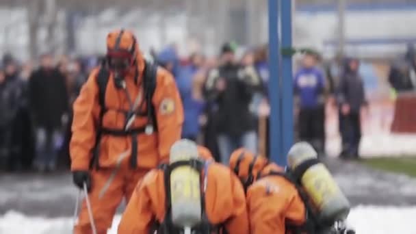 SAINT PETERSBURG, RUSSIA - NOVEMBER 28, 2015: Men in protect suits, masks put man on stretcher. Emercom practice. Audience — 图库视频影像