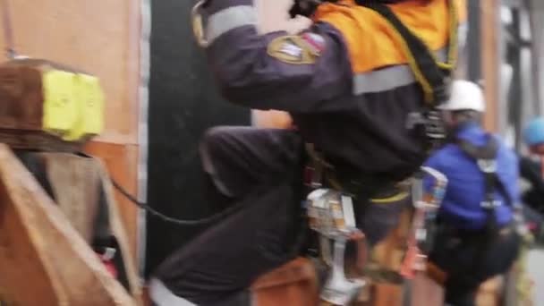 SAINT PETERSBURG, RUSSIA - NOVEMBER 28, 2015: Men in helmet rescue uniform hang on rope at wall, attach carbine. Training — стокове відео