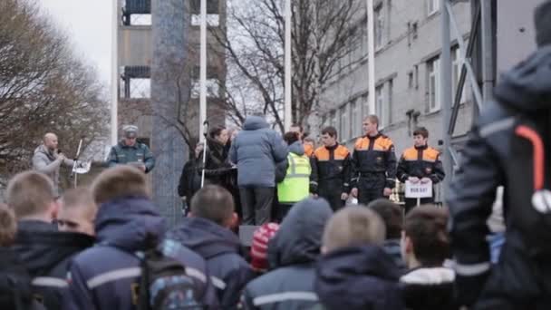 SAN PETERSBURG, RUSIA - 28 DE NOVIEMBRE DE 2015: Mujer y hombre cuelgan medallas de oro en uniformes de rescate para jóvenes en el escenario callejero . — Vídeo de stock