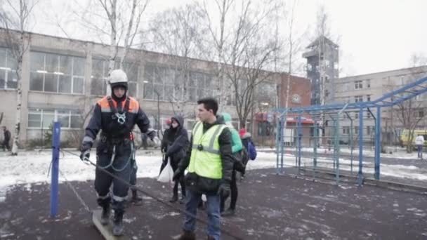 SAN PETERSBURG, RUSIA - 28 DE NOVIEMBRE DE 2015: Niño en casco, equipo de rescate tren mantener el equilibrio en la tabla de agitación. Emercom — Vídeos de Stock