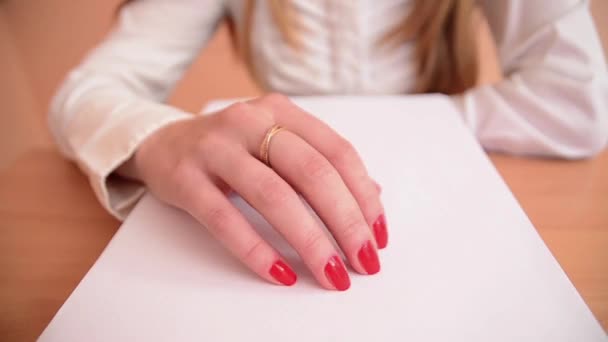 赤い爪を持つ女性は、テーブルの上の白い表面をタップします。クローズ アップ. — ストック動画