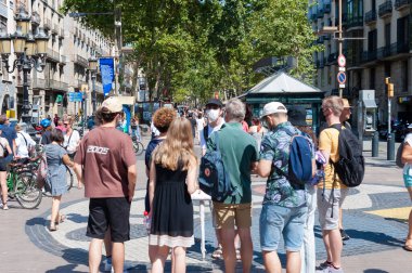Barselona, İspanya; 19 Temmuz 2021: Beşinci dalganın COVID-19 vakalarının görüldüğü bir dönemde, Barselona 'daki Rambla gezinti alanında kültür turu yapan bir grup turist. Yurt endüstrisinde sokağa çıkma yasağı var.
