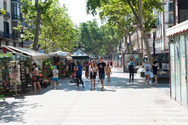 Barselona, İspanya; 19 Temmuz 2021: Beşinci dalganın COVID-19 vakalarının görülme oranı artarken, Barcelona 'daki Ramblas boyunca gezinen bir grup turist. Yurtta sokağa çıkma yasağı varken..