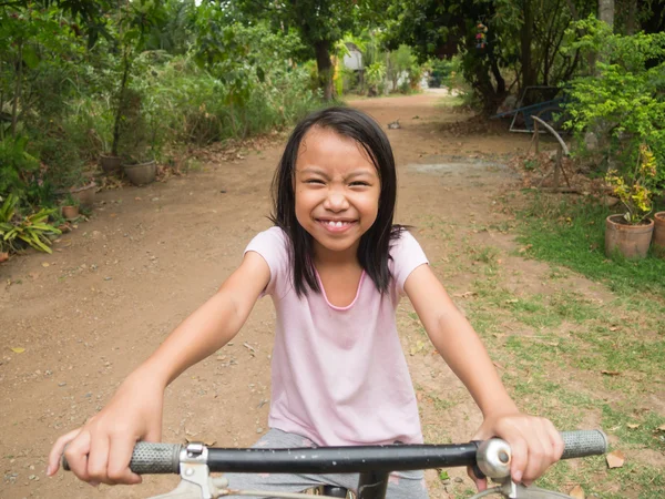 Feliz poco asiático niño a caballo bicicleta en el parque — Foto de Stock