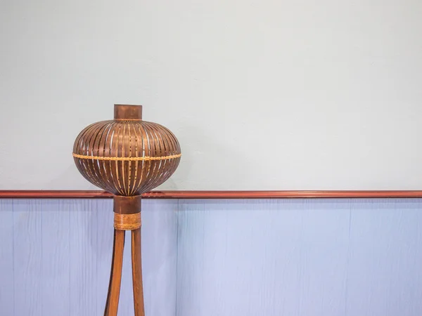 Wood lamp placed in front of a blue wall.