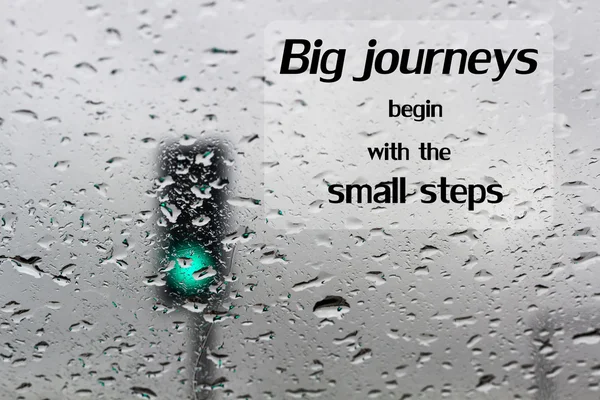 Word Big journeys begin with the small  motivational  quote on traffic light on a rainy day window background - Stock Image -  Everypixel