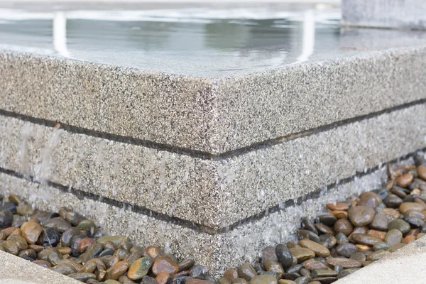 El desbordamiento de agua forma estanque a bajo la piedra — Foto de Stock