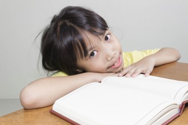 Asyalı kız çocuk mutlu çalışma notları beyaz kağıt kitap yazma onun elinde onun kalem ile oturma odasında