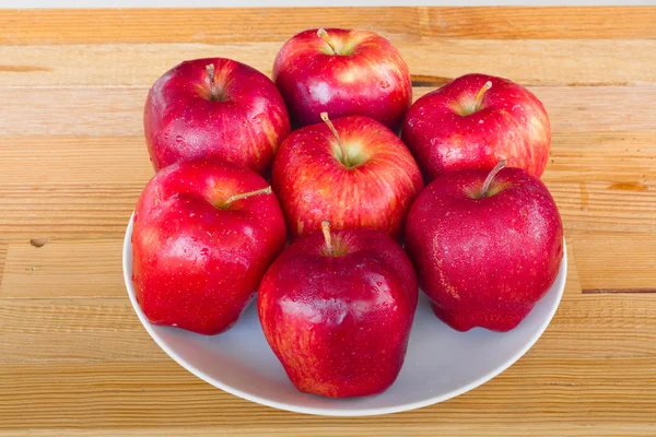 흰색 세라믹 접시 나무 배경에 신선한 빨간 사과 — 스톡 사진