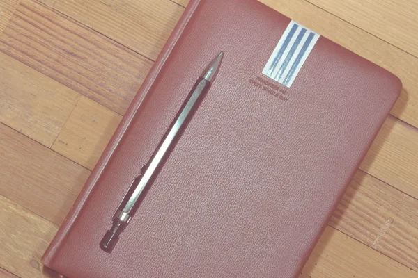 A notebook a fából készült asztal, üzleti koncepció - Vintage hatású stílus képek ceruza — Stock Fotó