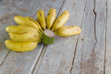 Ahşap arka plan üzerinde olgunlaşmış muz demet