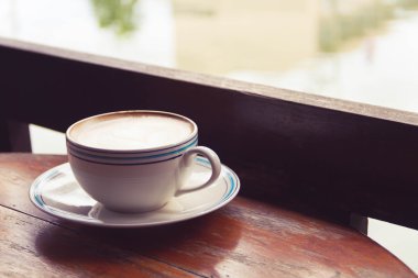 Bir fincan kahve latte sanat eski ahşap arka plan - Vintage filtre efekti üzerinde kapatın