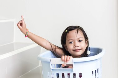 Güzel küçük Asyalı kız mavi sepete oynarken