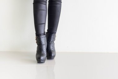 Siyah deri pantolon ve yüksek topuklu ayakkabı giyen kadın