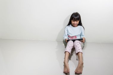 Çocuk tablet bilgisayar ile oturup yere - teknoloji ve çocuk kavramı