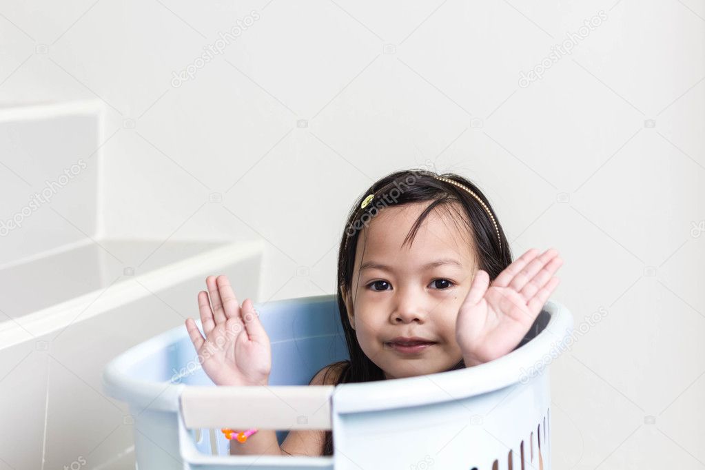Beautiful little asian girl  playing in blue basket