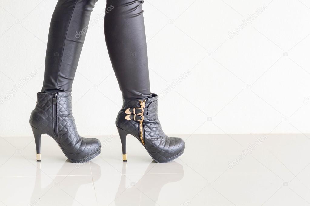 Woman wearing black leather pants and high heel shoes