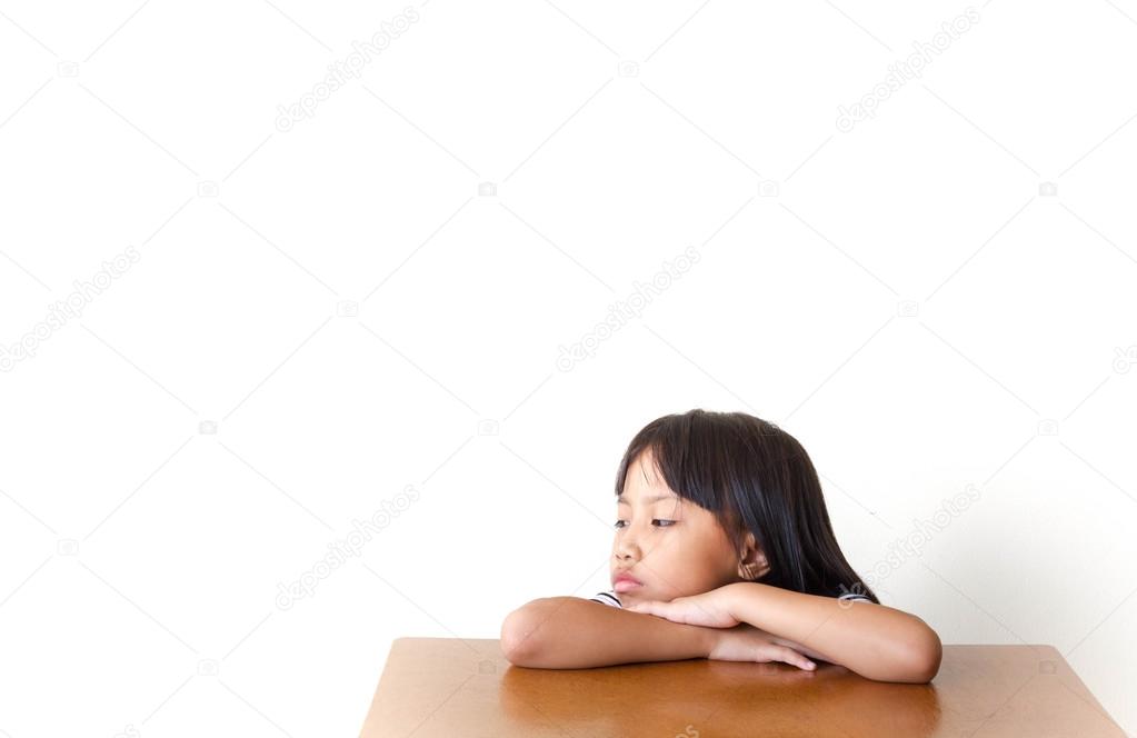Bored children girl sitting at the table