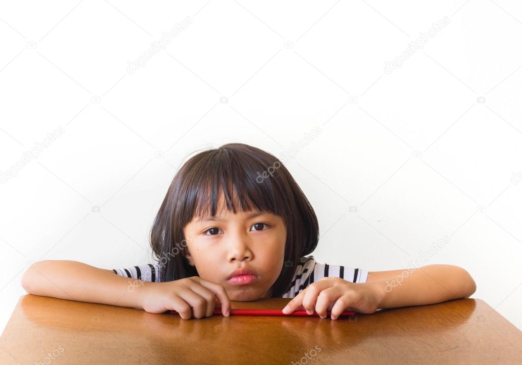 Joyful children girl with red chopsticks sitting at the table