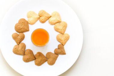 Çikolata kurabiye ve havuç suyu beyaz arka plan üzerinde beyaz çanak üzerinde kurabiyeleri