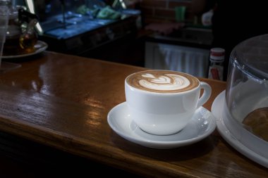 Beyaz fincan kahve, latte ahşap masa üzerinde kapatın