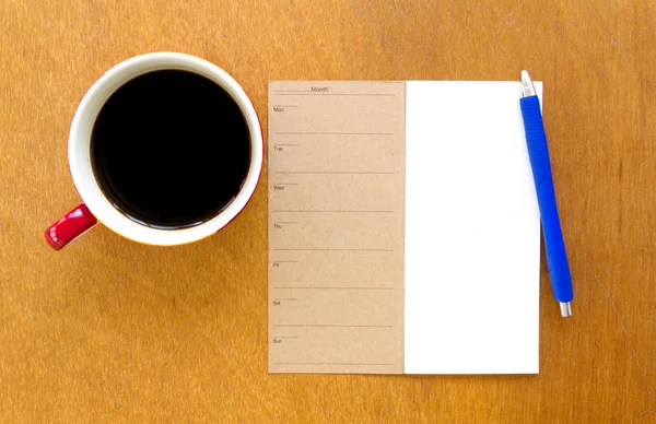 Порожній блокнот пам'яті та синя ручка з кавою на дерев'яному фоні — стокове фото