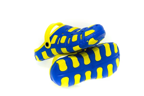 Sandalias de goma azul y amarilla sobre fondo blanco —  Fotos de Stock