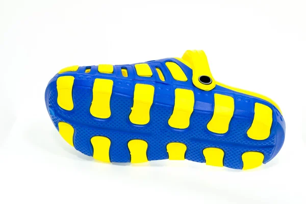 Blaue und gelbe Gummisandalen auf weißem Hintergrund — Stockfoto