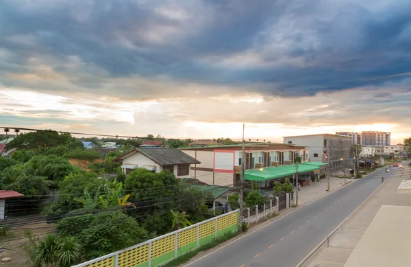 Estrada e edifícios na cidade com pôr do sol — Fotografia de Stock