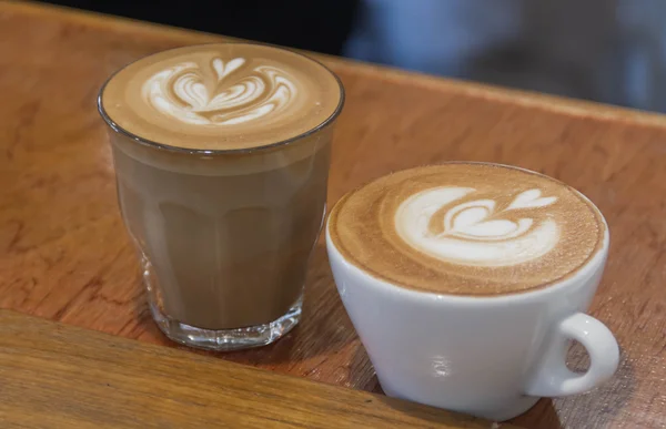 Feche a xícara branca de café, café com leite na mesa de madeira — Fotografia de Stock