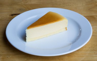 Cheesecake ile çanak ahşap arka plan üzerinde