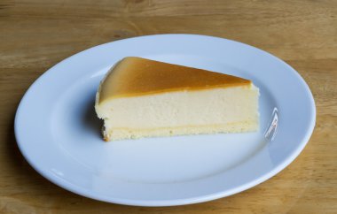 Cheesecake ile çanak ahşap arka plan üzerinde