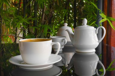 Mavi fincan kahve, latte siyah cam masa üzerinde kapatın