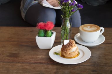 Pasta krem kahve bir ahşap zemin üzerinde bir tabak içinde.