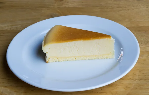 Käsekuchen mit Gericht auf Holzgrund — Stockfoto