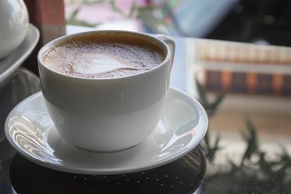 Fermer tasse bleue de café, latte sur la table en verre noir — Photo