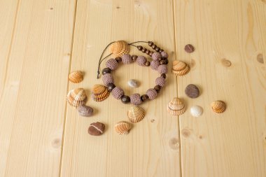 El yapımı boncuk, deniz taşları ve kabukları üzerinde bir ahşap tığ işi