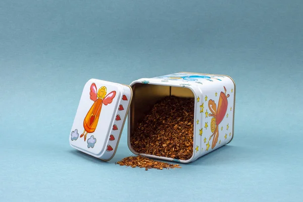 Rooibos çay üzerinde mavi bir arka plan ile kare teneke kutu