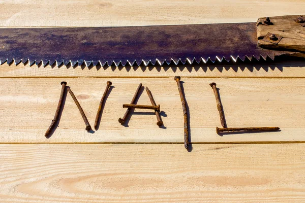 Paslı testere ve ahşap masa üzerinde paslı çivi