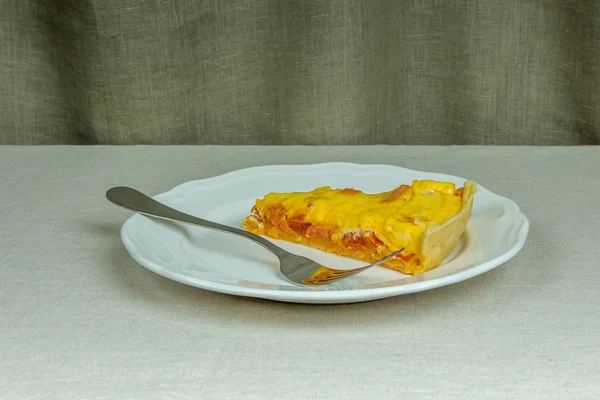 Vydatné domácí koláč z listového těsta, jeden kus na bílé desce — Stock fotografie