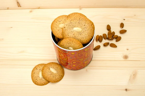 Homemade macaroons in tin and almonds top view