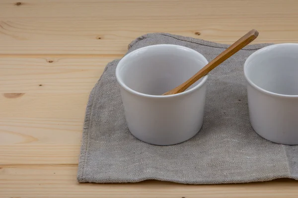 Gri keten peçeteler üzerinde beyaz seramik pişirme çanağı