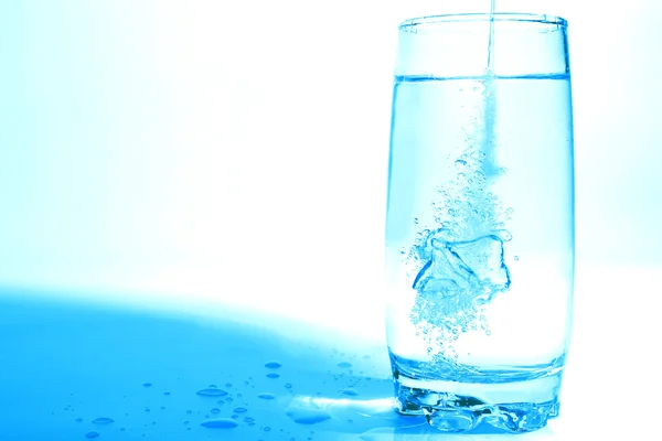 Agua que vierte en vidrio transparente con burbujas de aire — Foto de Stock