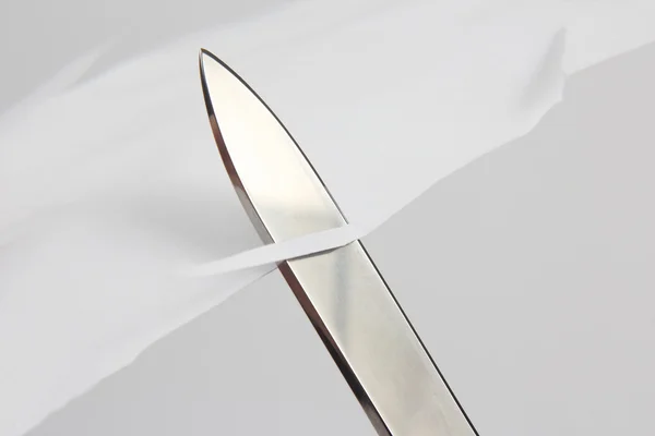 ホワイト ペーパーを横切る鋭いナイフの刃 — ストック写真