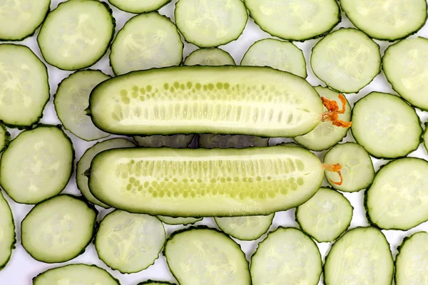 Corte longitudinalmente o pepino no fundo do pepino fatiado — Fotografia de Stock